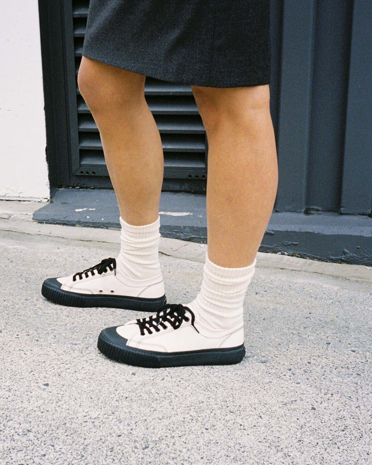 Wearing Buddy x CC Hemp Off-White/Black trainers with white socks and dark shorts on concrete