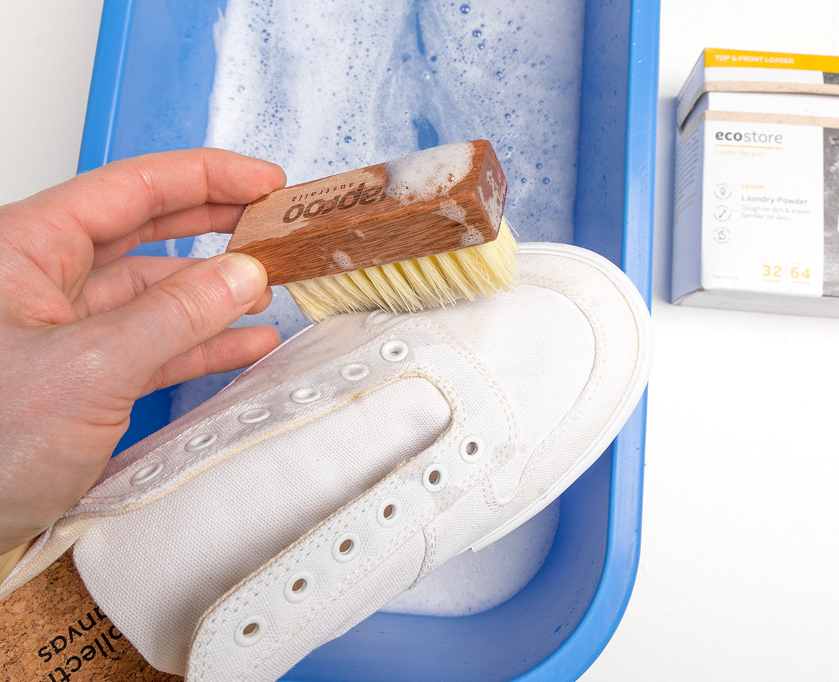 White Collective Canvas trainer being scrubbed with soapy water.