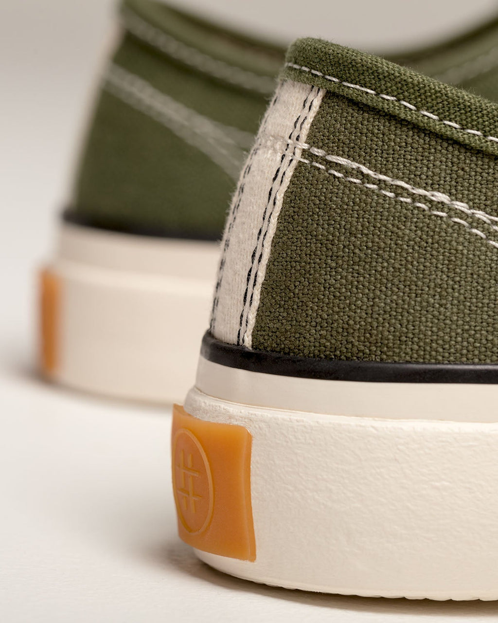Close-up of Straat Olive heel with contrast stitching and embossed orange heel tab