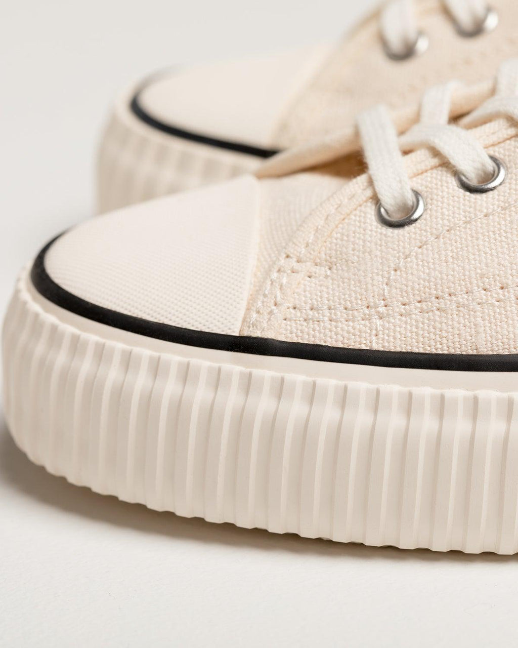 Close-up of Straat Natural/Black toe cap with black stripe and ribbed off-white rubber sole