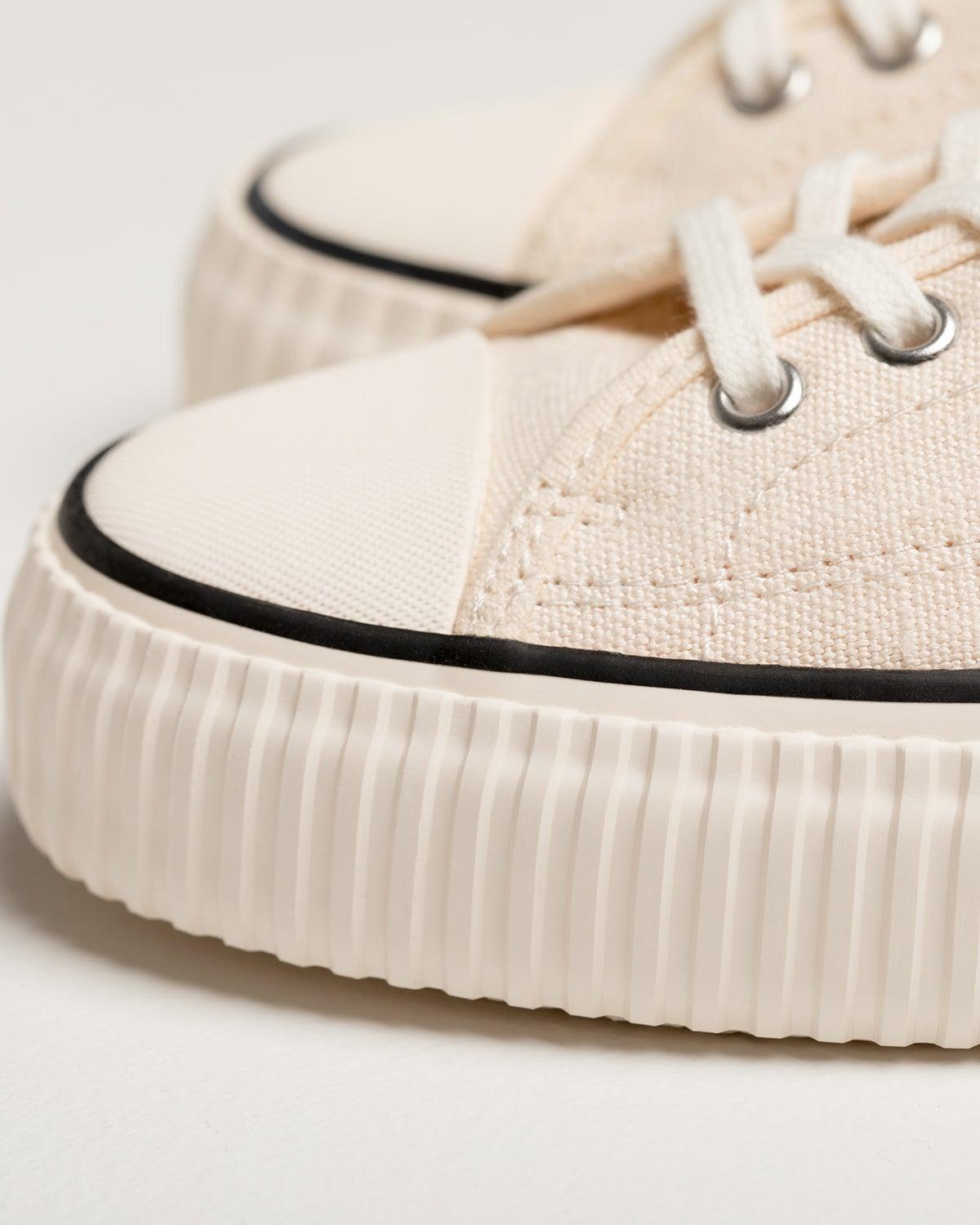 Close-up of Straat Natural/Black toe cap with black stripe and ribbed off-white rubber sole