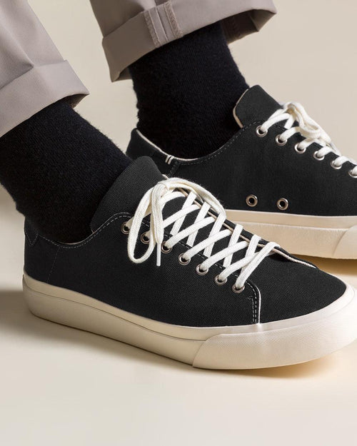 Wearing Baan Black/White trainers with black socks and rolled grey trousers
