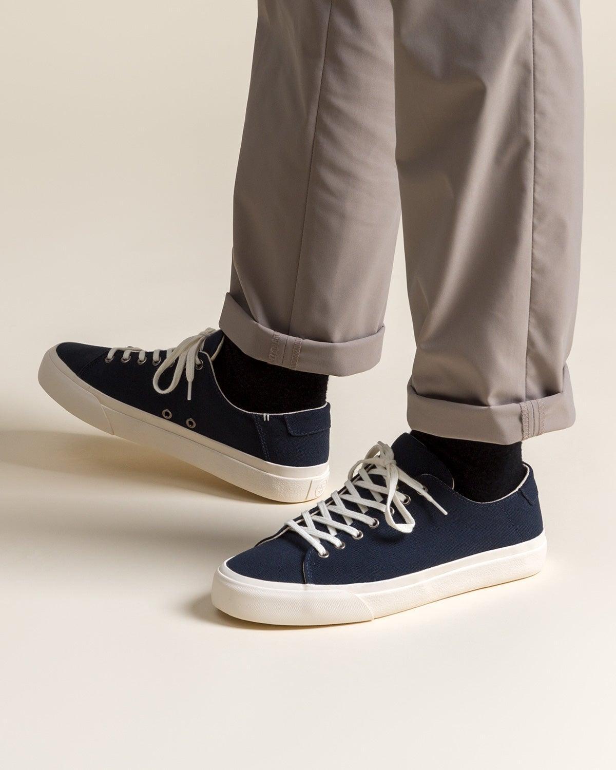 Wearing Baan Navy trainers with black socks and rolled grey trousers