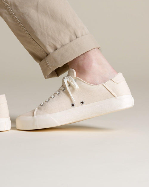 Wearing Baan Natural trainers with rolled beige chinos, mid-step