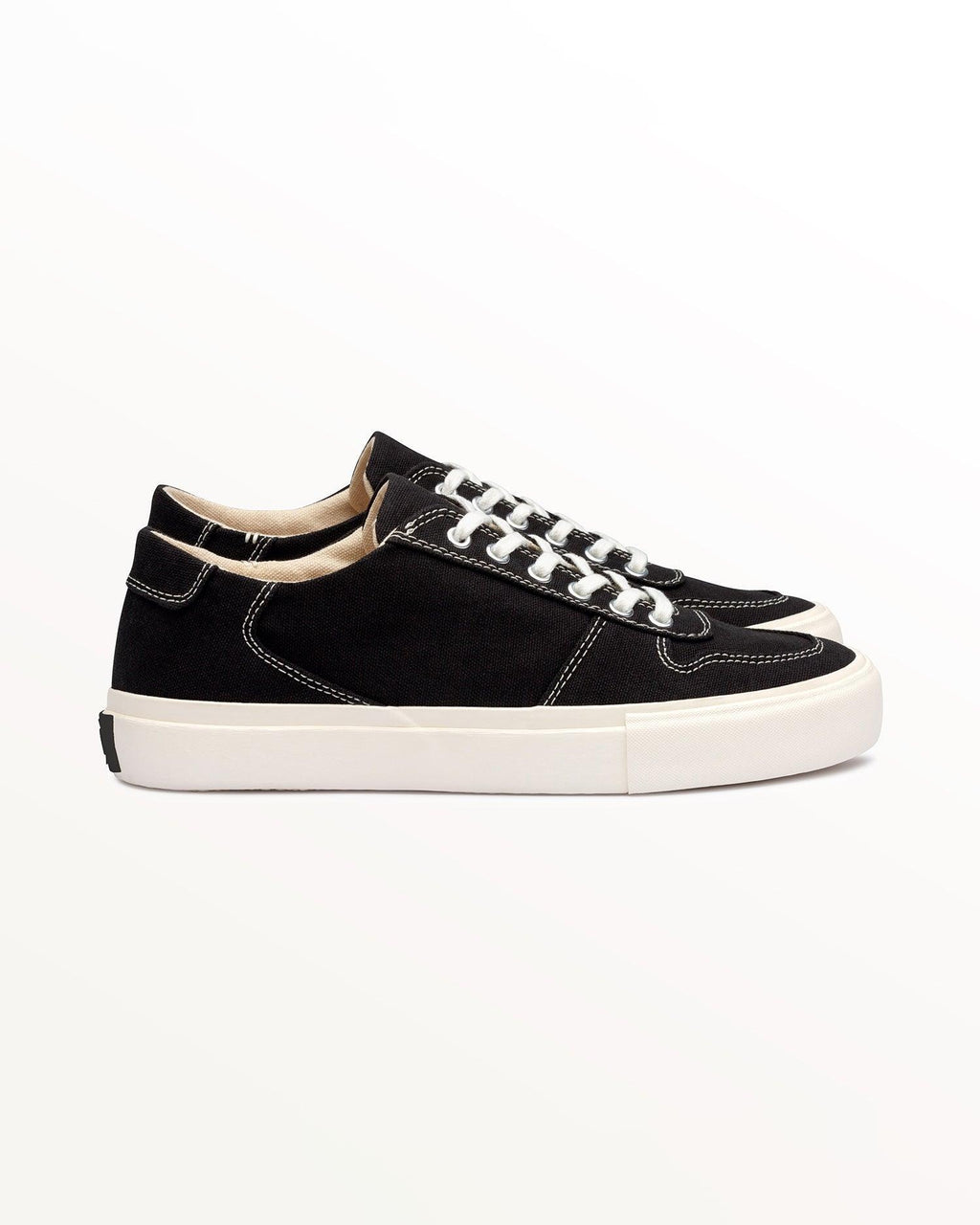 Bal Black/White low-top trainer, side view with white contrast stitching and off-white rubber sole