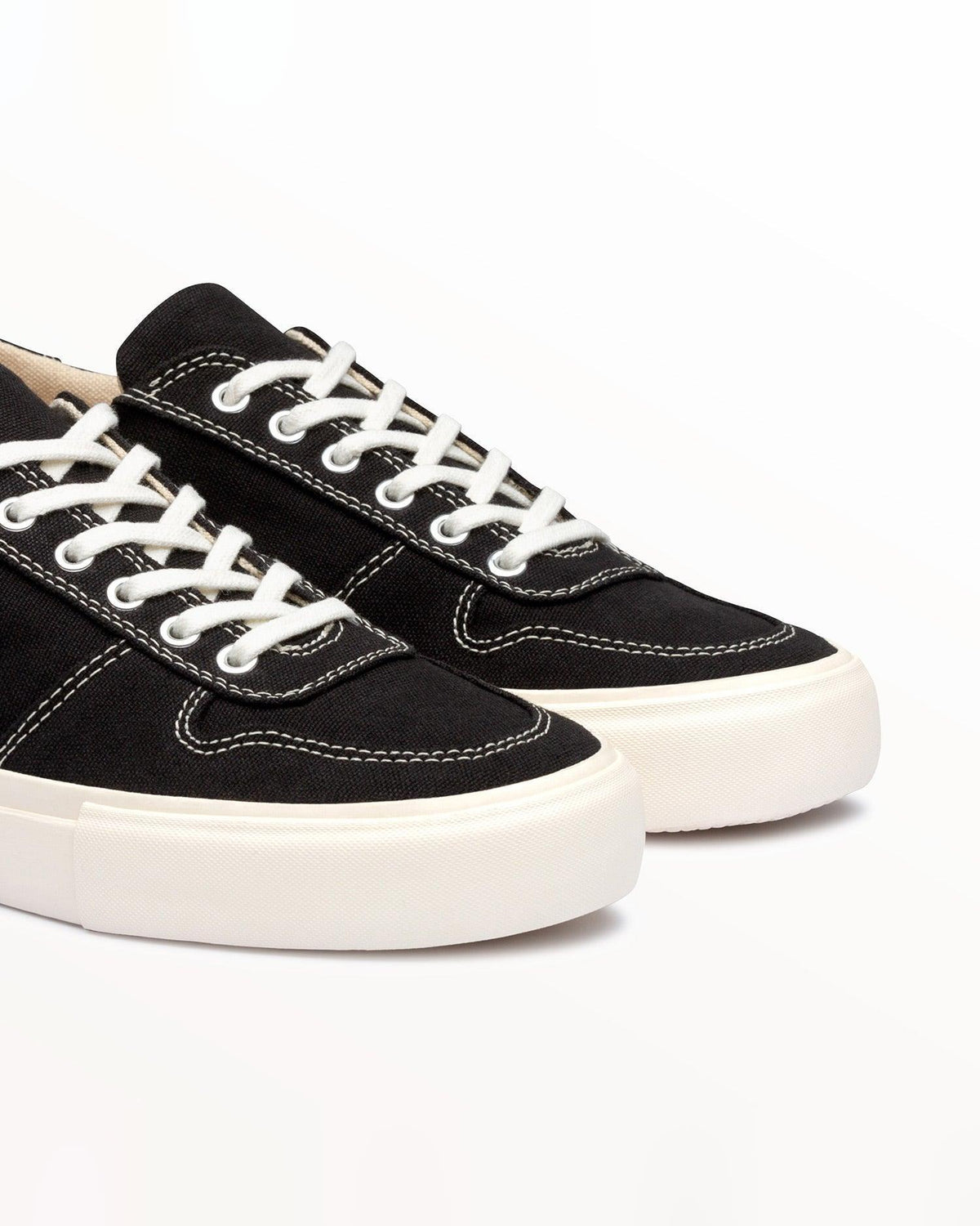 Close-up of black organic cotton canvas upper with white stitching and white laces on Bal Black/White