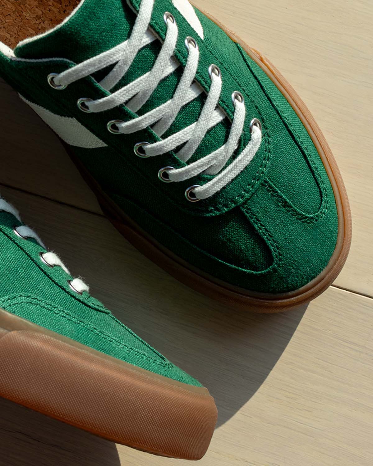 Close-up of Veld Hemp Sage/Ecru trainers from above on a light wooden floor
