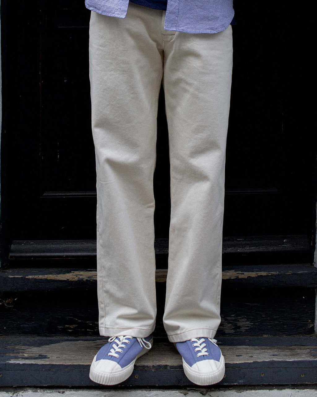 Wearing CC x Original Fibres Stonewash trainers with stone chinos on a dark doorstep
