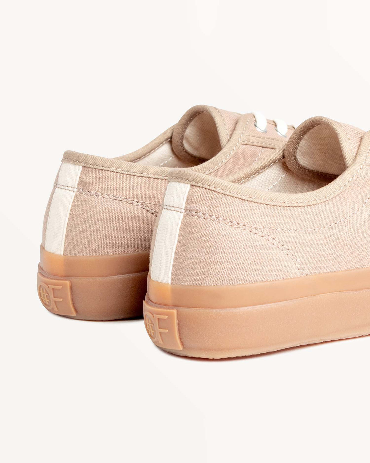 Close-up of CC x Original Fibres Greige heels with embossed OF logo on the natural gum rubber sole