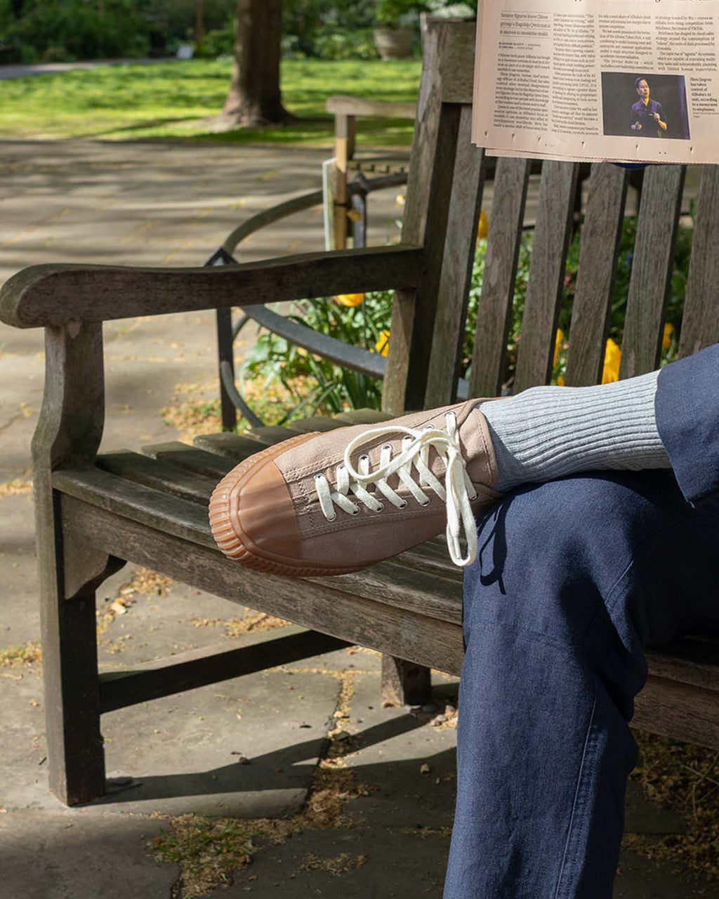 CC x Original Fibres Greige trainers worn with grey socks and blue trousers on a park bench