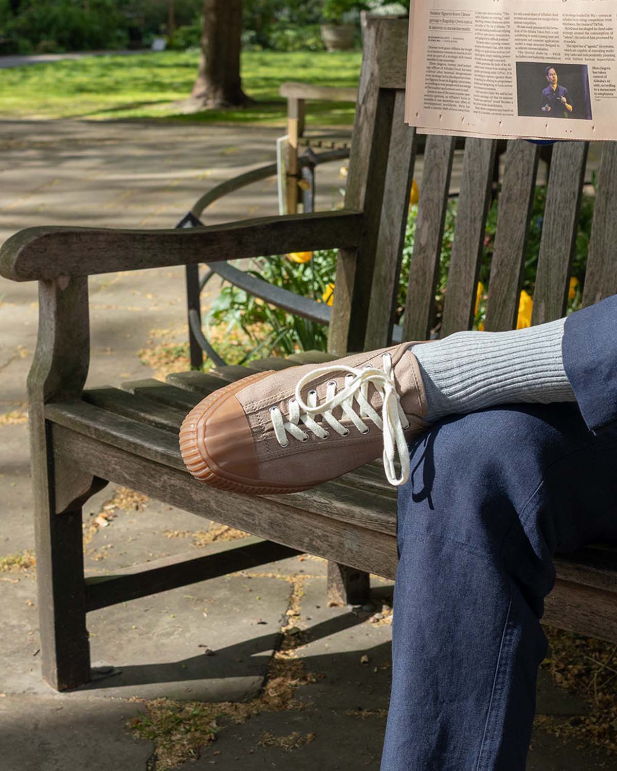 CC x Original Fibres Greige trainers worn with grey socks and blue trousers on a park bench