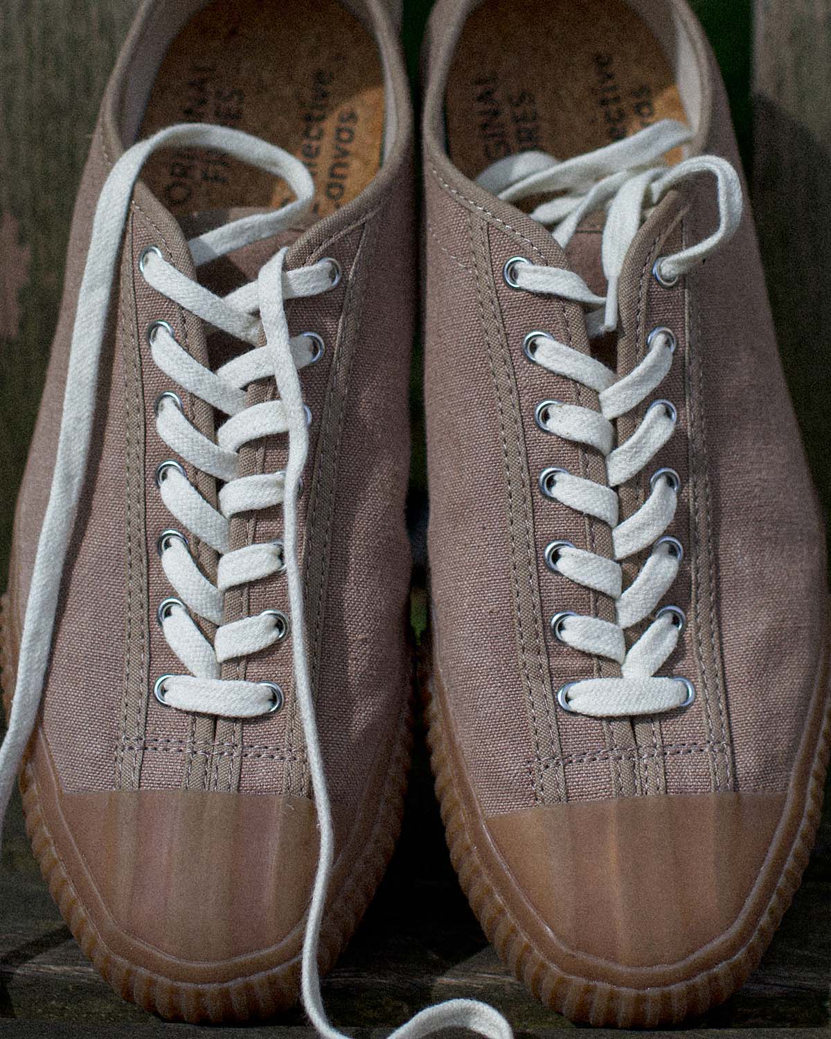 CC x Original Fibres Greige trainers from above on a wooden bench, laces untied