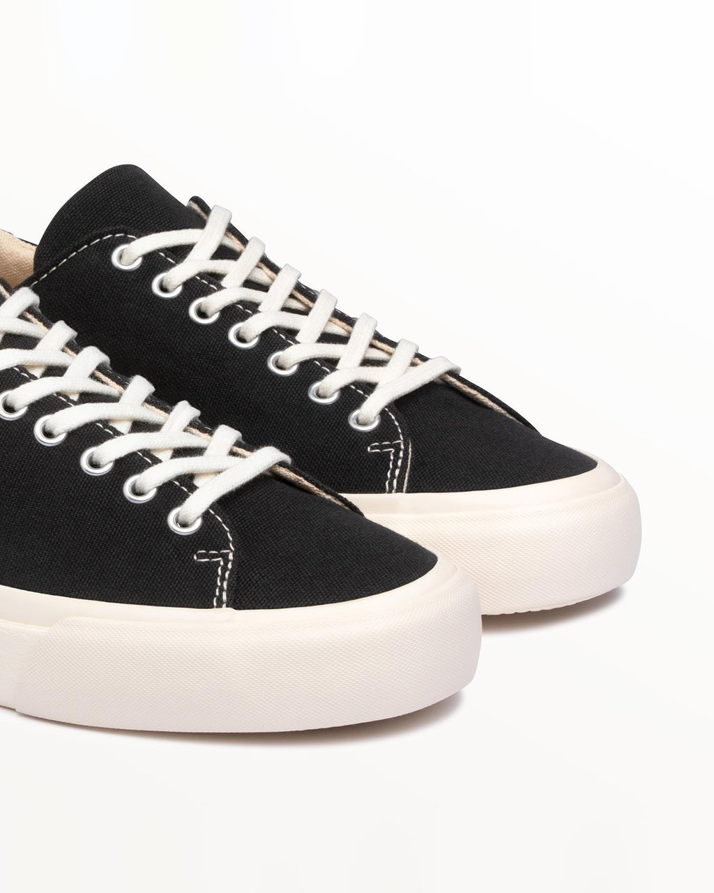 Close-up of black organic cotton canvas upper and white laces on Baan Black/White