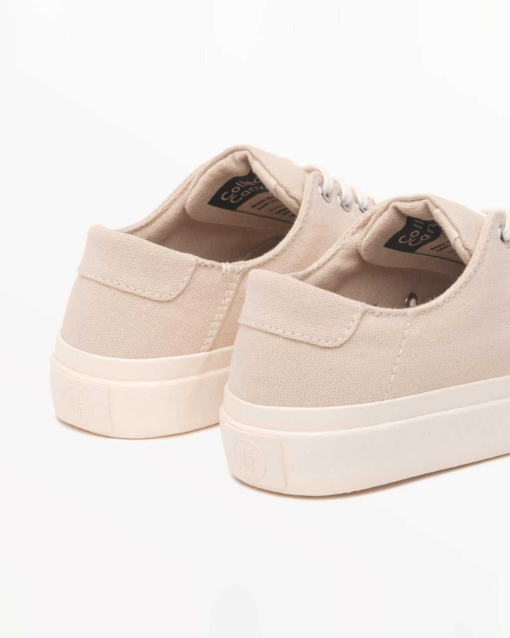 Close-up of Baan Natural heels with woven inner label and embossed logo on the off-white rubber sole