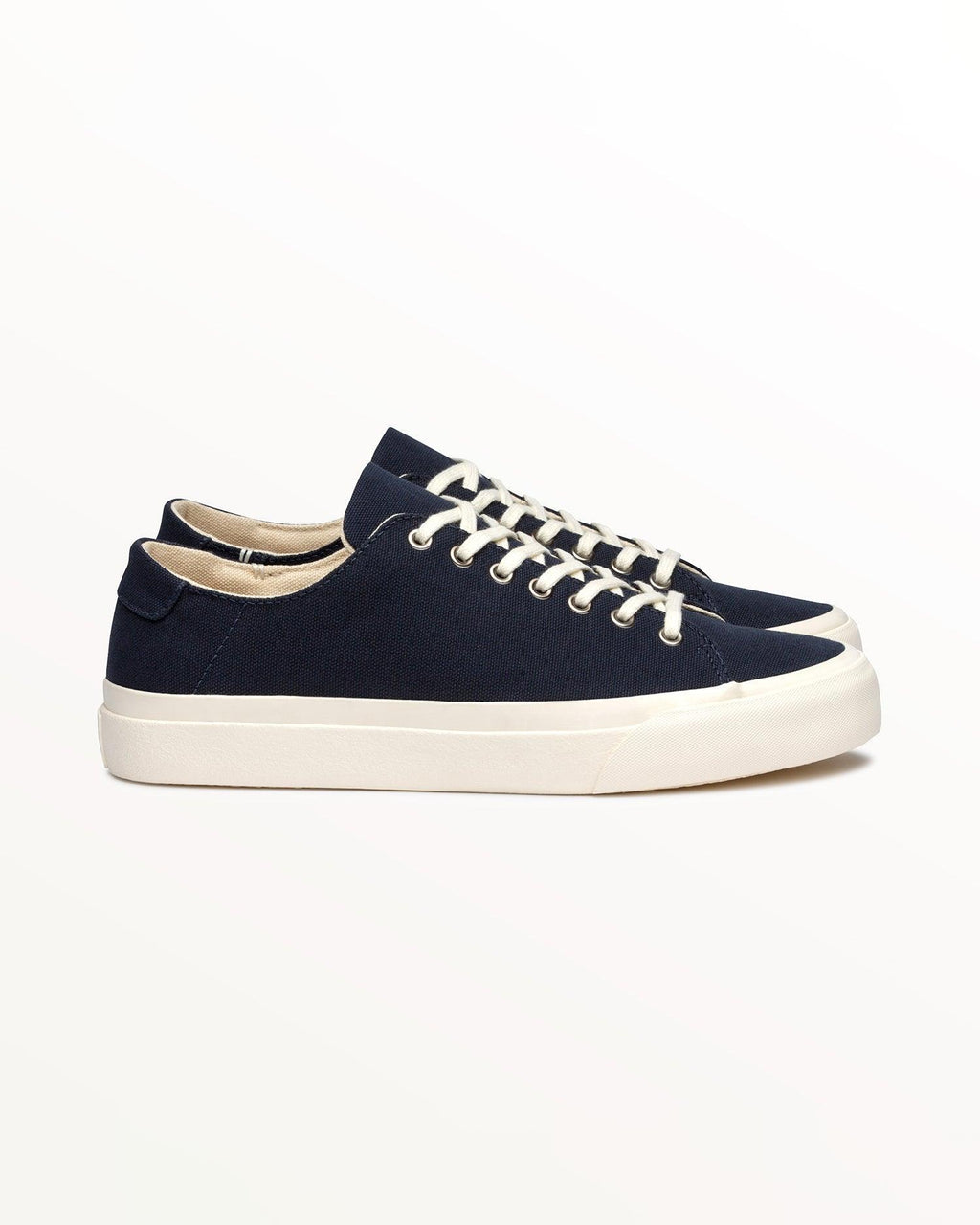 Baan Navy trainer, side view of organic cotton canvas upper on an off-white rubber sole