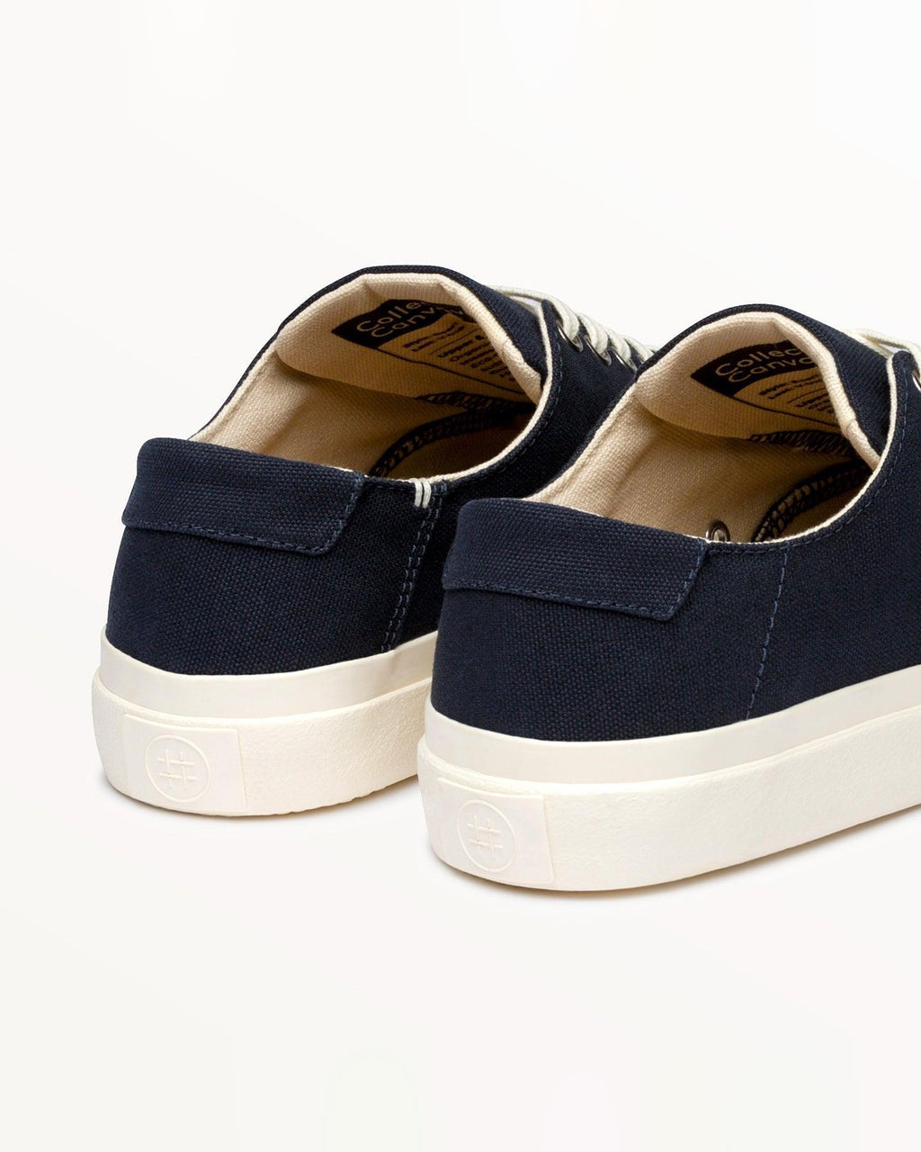 Close-up of Baan Navy heels with woven inner label and embossed logo on the off-white rubber sole