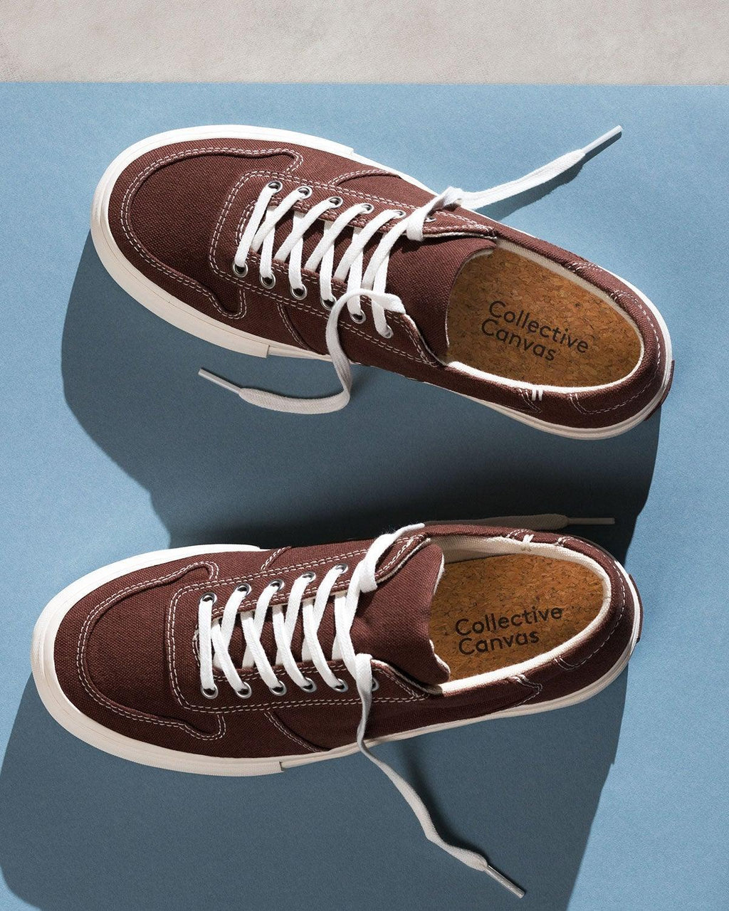 Pair of Bal Cappuccino trainers from above on a blue background, laces loose