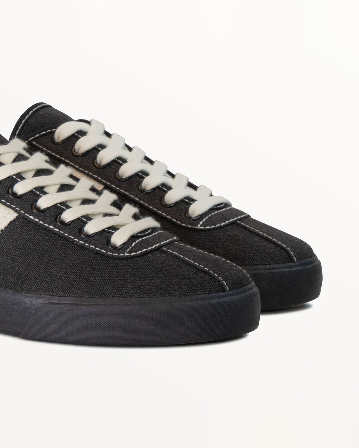 Close-up of black hemp canvas upper with white stitching and white laces on Looper Black/White Stitch
