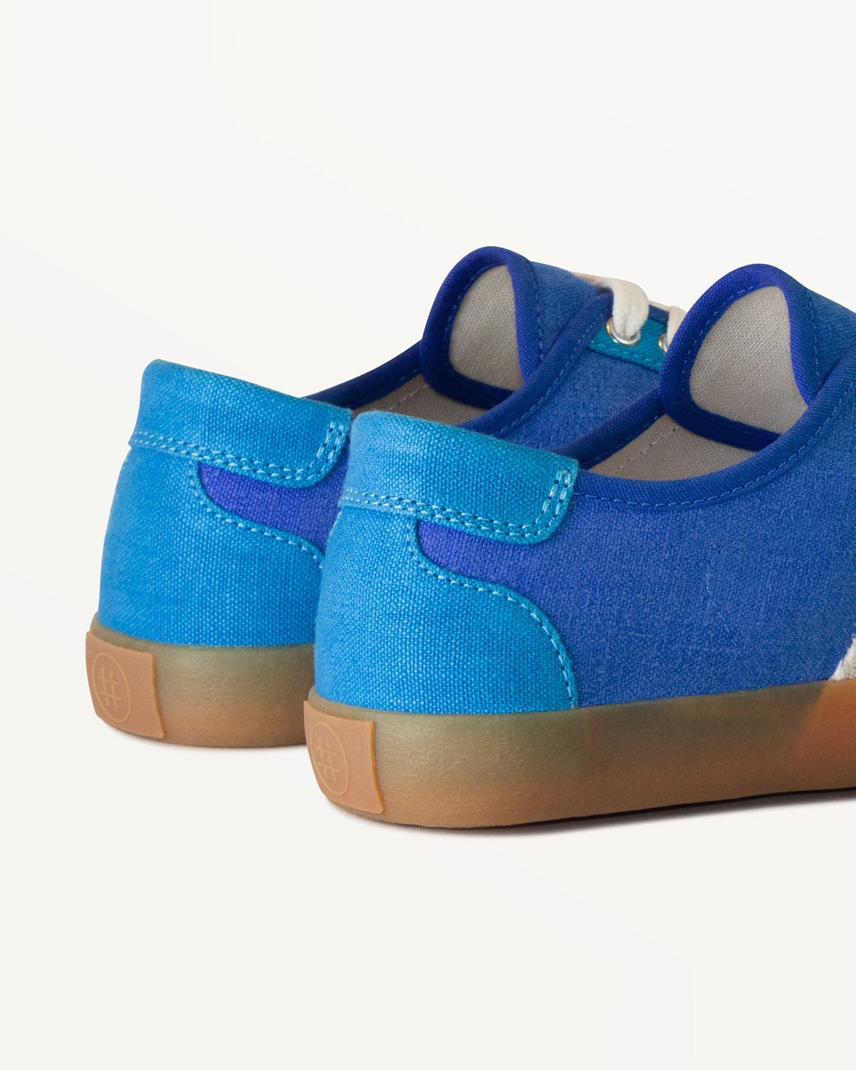 Close-up of Looper Blue heel with light blue heel tab and embossed logo on the natural gum rubber sole