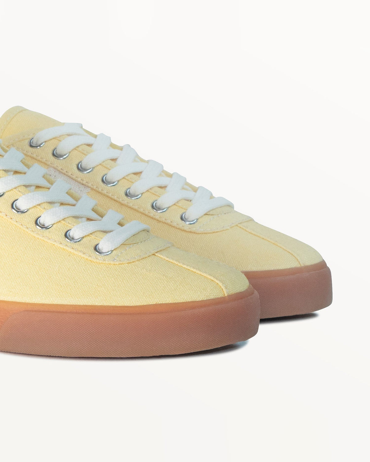 Close-up of pale yellow hemp canvas upper, white laces and metal eyelets on Looper Butter/Ecru