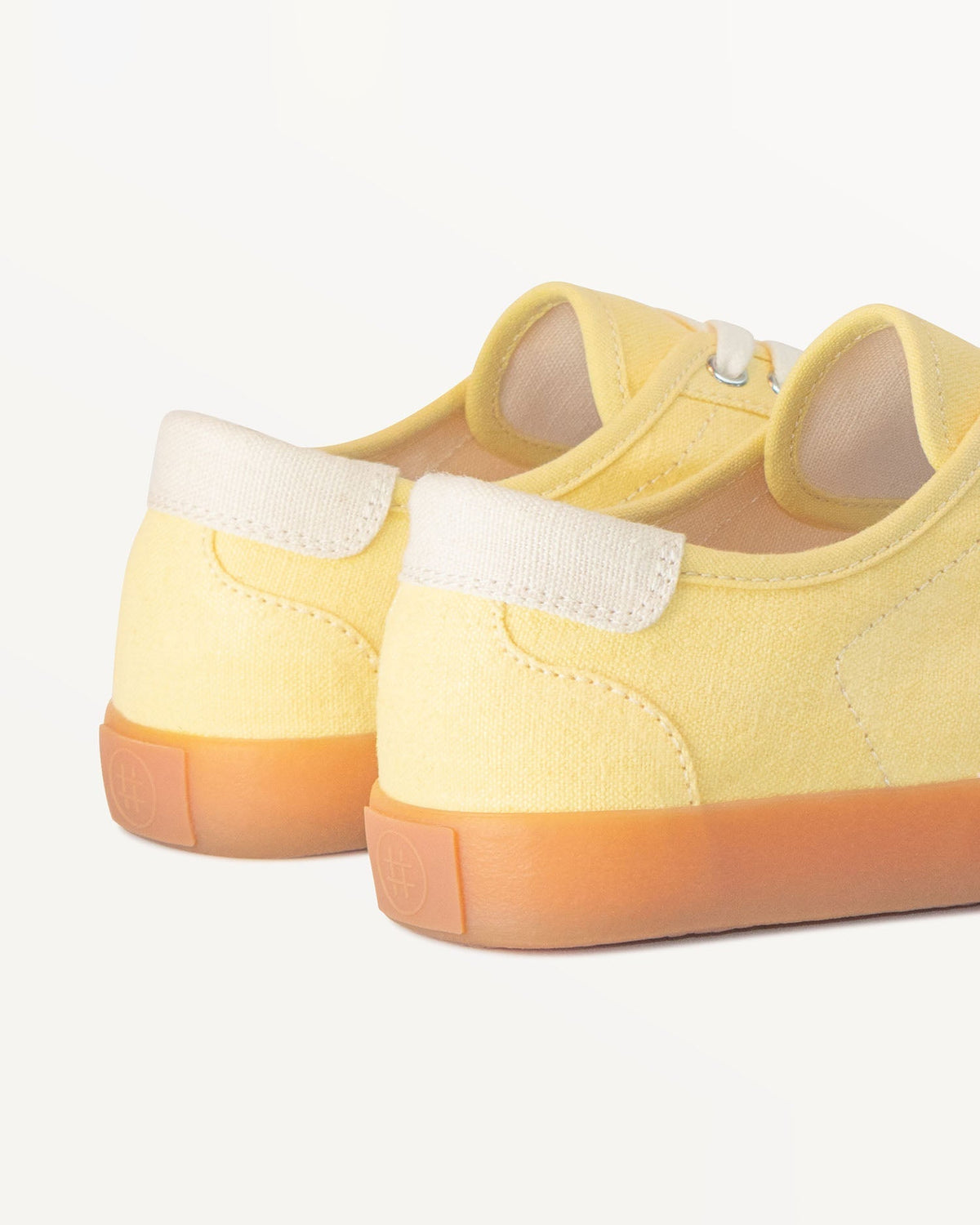 Close-up of Looper Butter/Ecru heel with ecru heel tab and embossed logo on the natural gum rubber sole