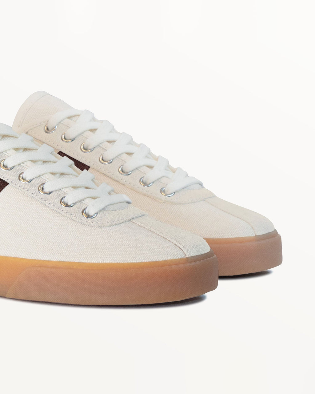 Close-up of ecru hemp canvas upper, white laces and metal eyelets on Looper Ecru/Coffee