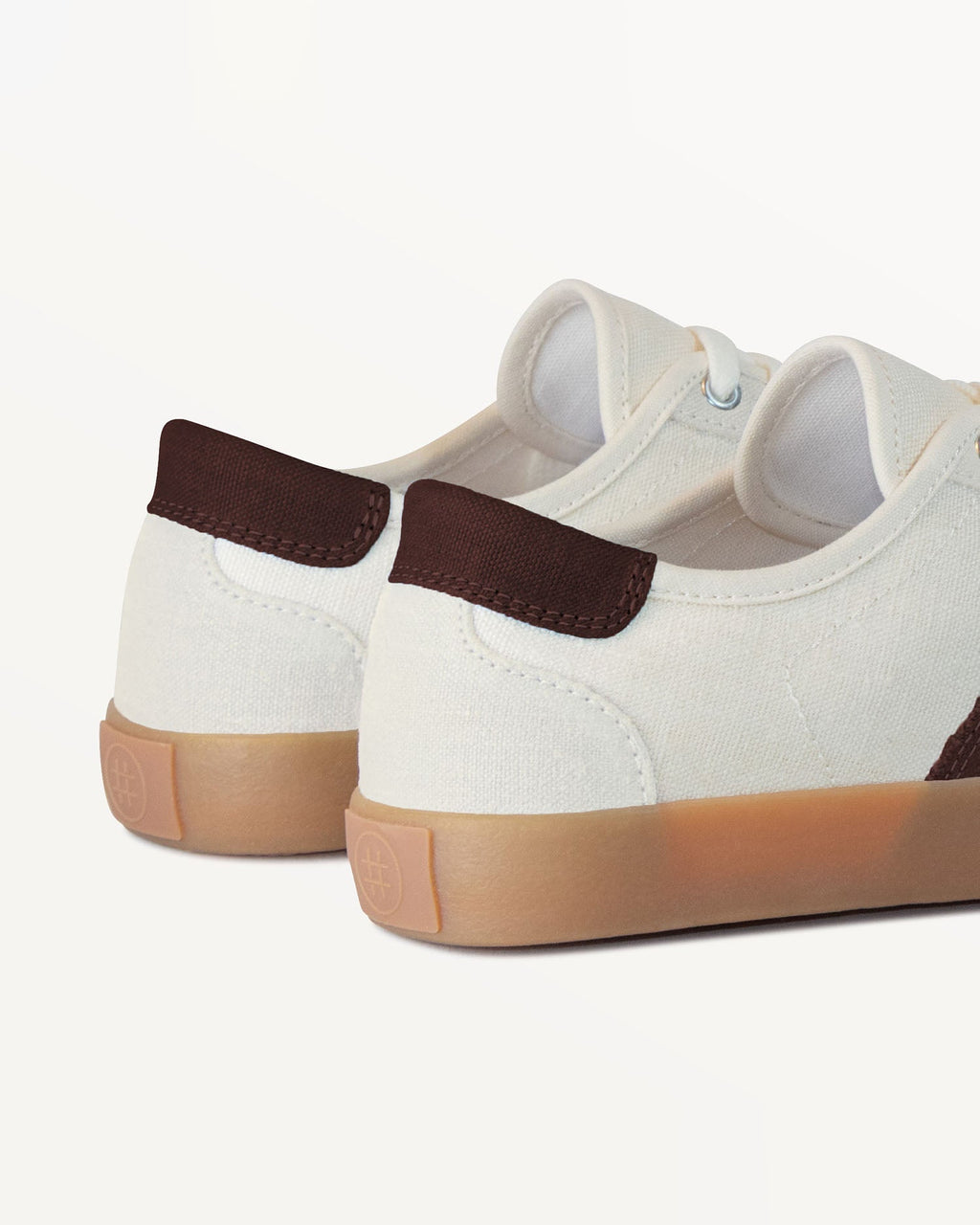 Close-up of Looper Ecru/Coffee heel with brown heel tab and embossed logo on the natural gum rubber sole