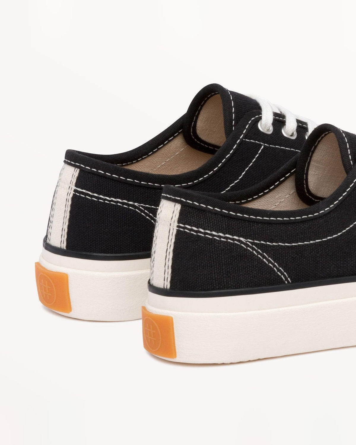 Close-up of Straat Black/White heels with white heel stripe and orange heel tab