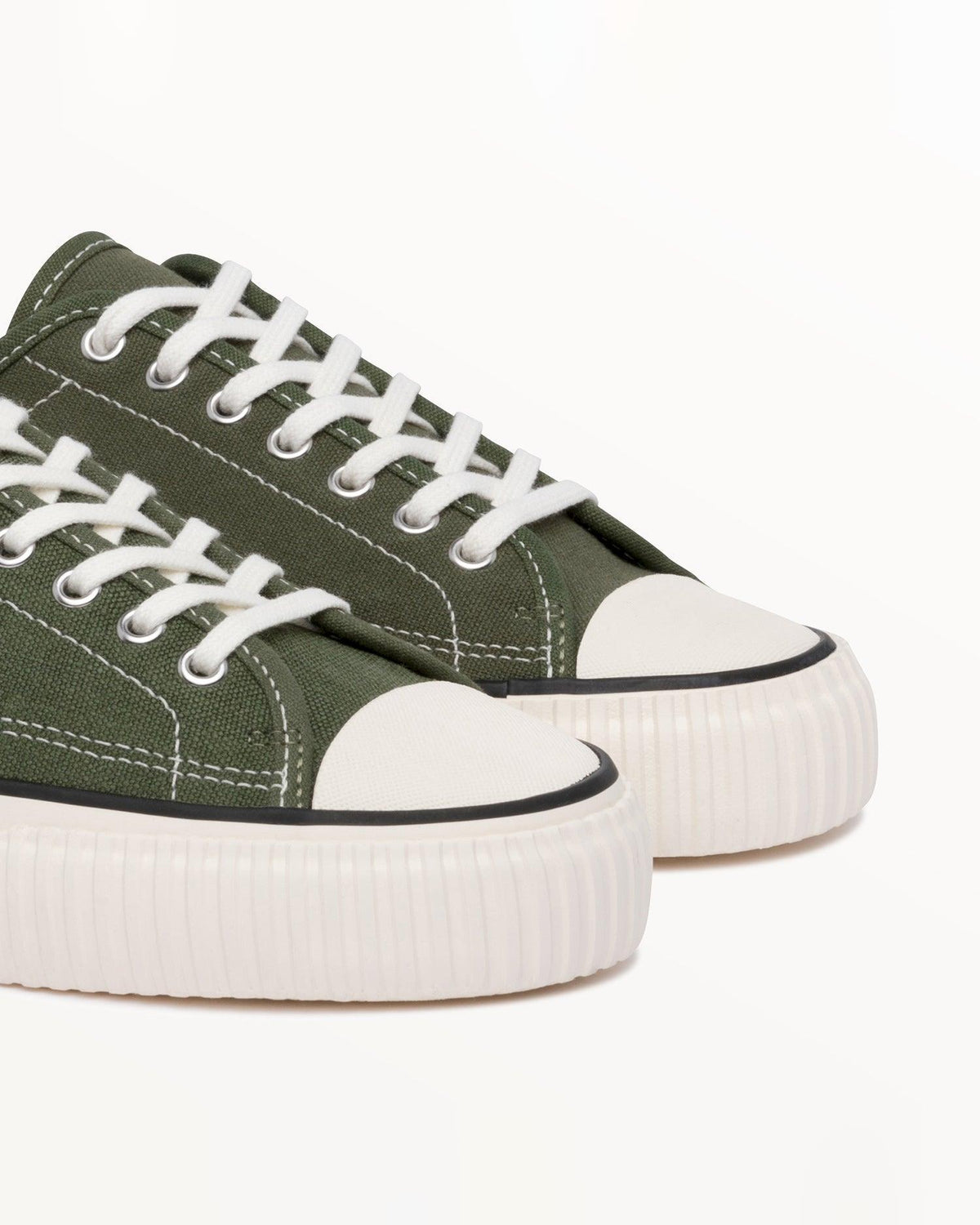 Close-up of olive hemp canvas upper, white laces and off-white rubber toe caps on Straat Olive
