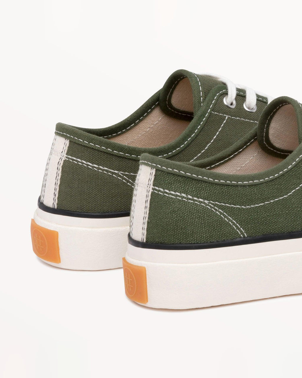 Close-up of Straat Olive heels with cream heel stripe and orange heel tab