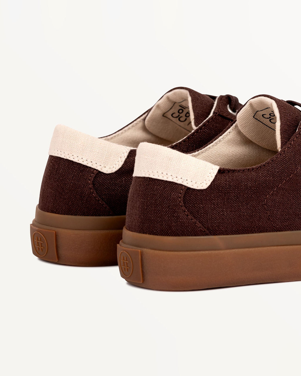 Close-up of Veld Coffee/Ecru heel with ecru heel tab and embossed logo on the natural gum rubber sole