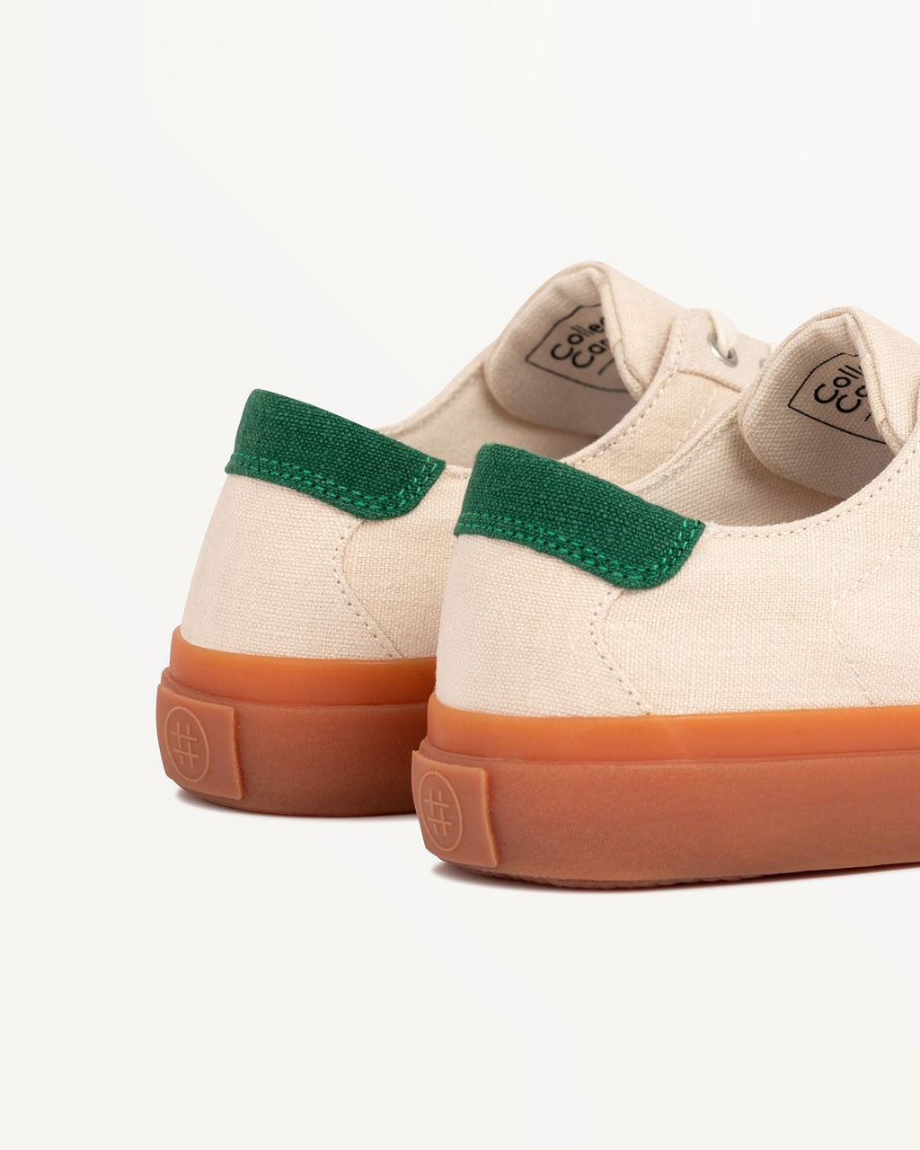 Close-up of Veld Ecru/Sage heel with green heel tab and embossed logo on the natural gum rubber sole